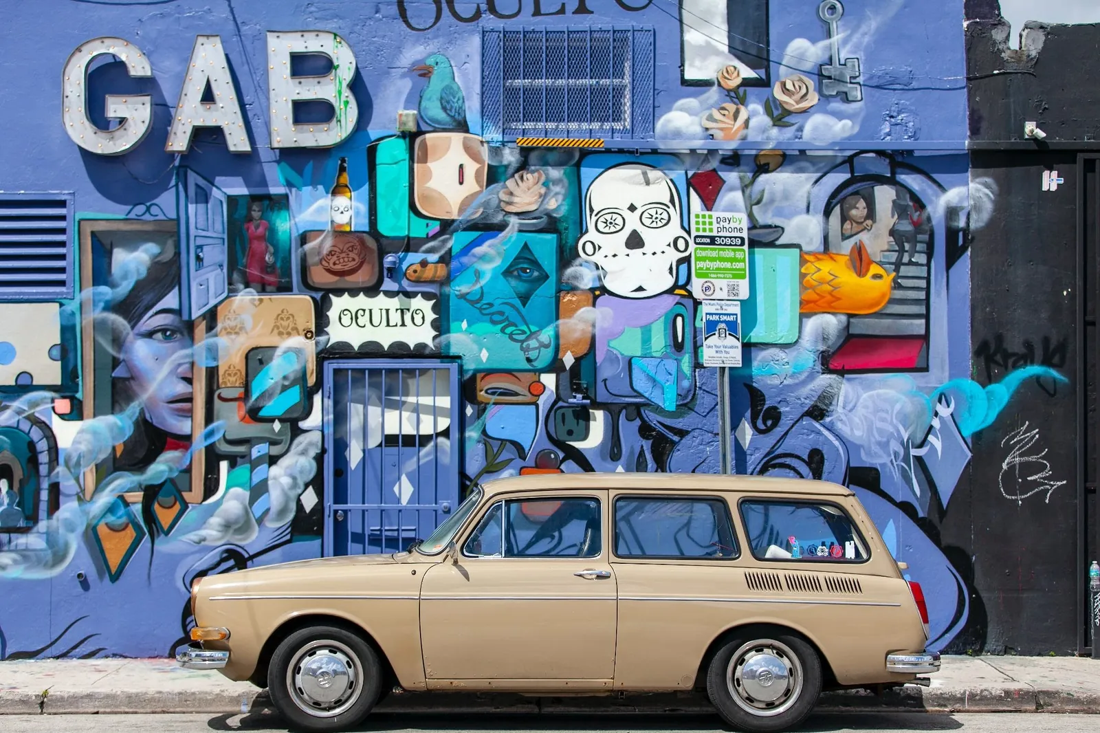 Light-colored car parked against a wall of vivid multicolored graffiti, demonstrating how strong contrast makes an element stand out