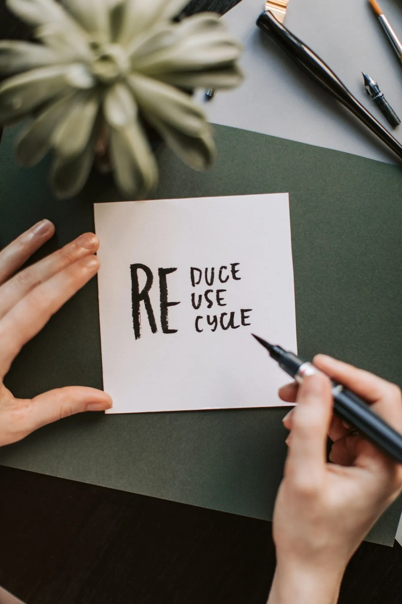 Person holding a pen over a mostly blank notebook page, showing how generous white space simplifies a layout and lets it breathe
